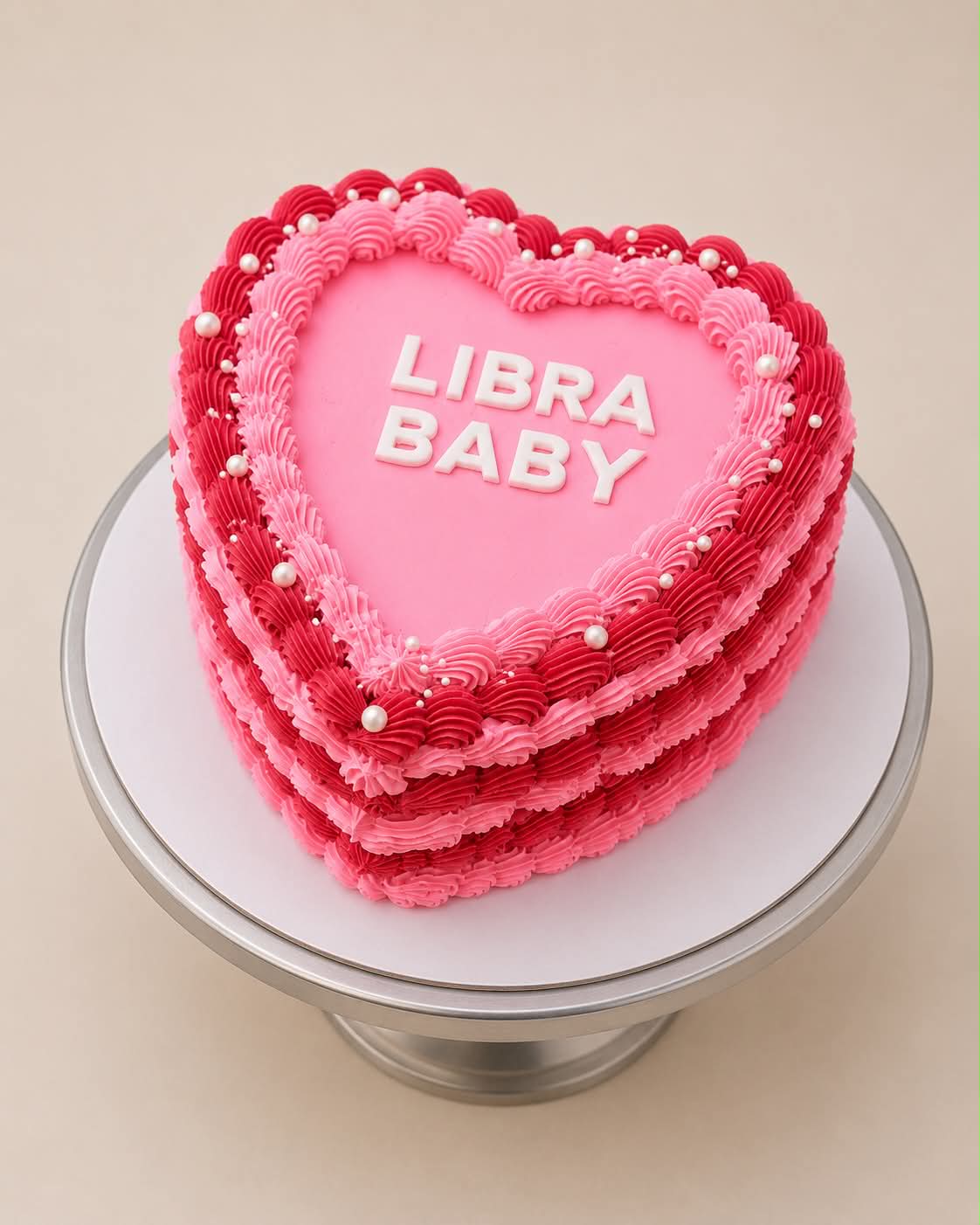 Hot pink and red heart cake with pearl decorations reading Libra Baby